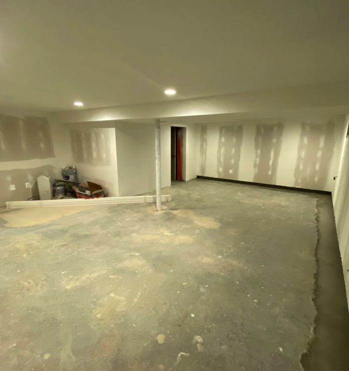 Another view of Springfield basement before renovation showing concrete walls